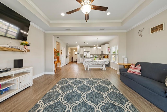 809 Whispering Creek Ave, Freeport, FL 32439 - living area with a raised ceiling, light wood-type flooring, a ceiling fan, baseboards, and crown molding