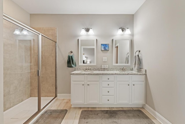 809 Whispering Creek Ave, Freeport, FL 32439 - bathroom with tiled shower, double vanity, wood finished floors, and baseboards