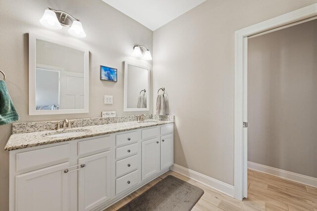 809 Whispering Creek Ave, Freeport, FL 32439 - full bathroom featuring wood finished floors, double vanity, and baseboards