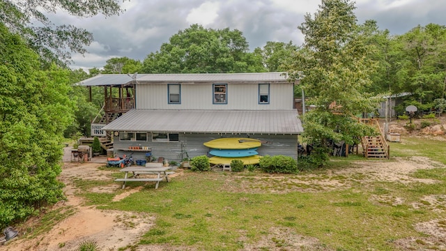 841 N 1st St, Defuniak Springs, FL 32433 - rear view of house with stairs, metal roof, a yard, and a wooden deck