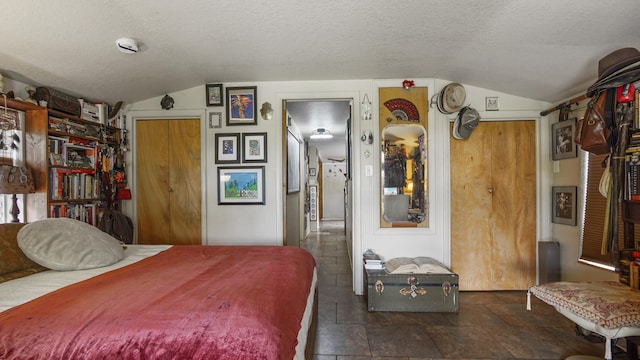 841 N 1st St, Defuniak Springs, FL 32433 - bedroom featuring lofted ceiling, a textured ceiling, dark stone finish flooring, and a closet