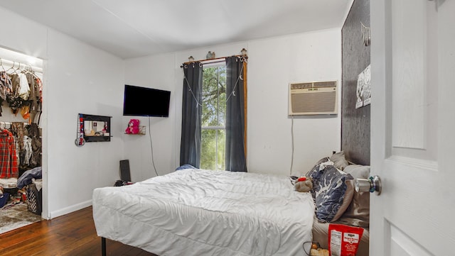 841 N 1st St, Defuniak Springs, FL 32433 - bedroom featuring dark wood-type flooring, a spacious closet, a closet, and a wall mounted air conditioner