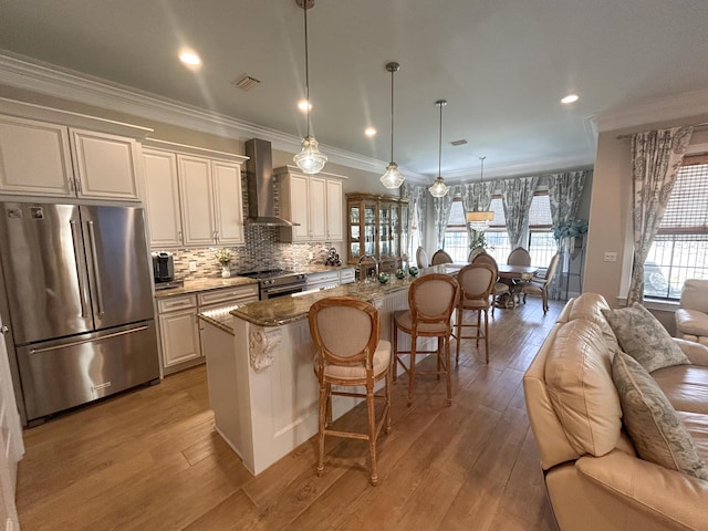 1976 Baytowne Loop, Miramar Beach, FL 32550 - kitchen featuring appliances with stainless steel finishes, wall chimney exhaust hood, open floor plan, a kitchen breakfast bar, and crown molding