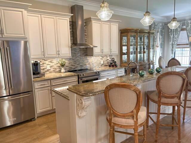 1976 Baytowne Loop, Miramar Beach, FL 32550 - kitchen with stainless steel appliances, wall chimney range hood, a kitchen breakfast bar, stone counters, and backsplash