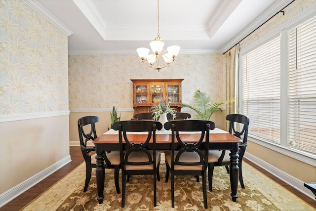 53 Concert Ct, Freeport, FL 32439 - dining space featuring a chandelier, wood finished floors, a tray ceiling, baseboards, and crown molding