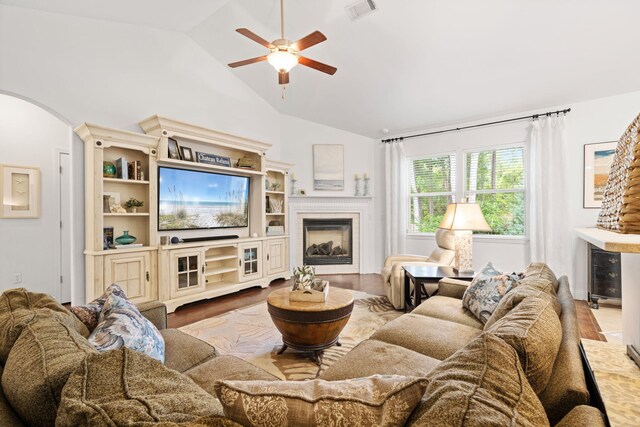 53 Concert Ct, Freeport, FL 32439 - living room featuring arched walkways, vaulted ceiling, ceiling fan, a tile fireplace, and wood finished floors