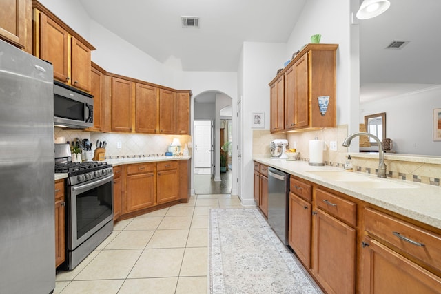 53 Concert Ct, Freeport, FL 32439 - kitchen featuring appliances with stainless steel finishes, a sink, backsplash, and arched walkways