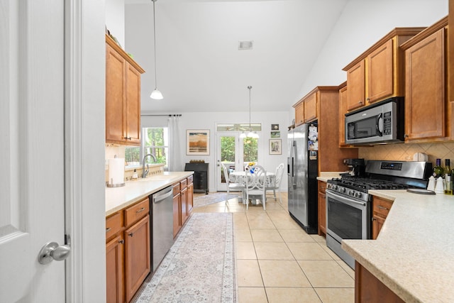 53 Concert Ct, Freeport, FL 32439 - kitchen featuring appliances with stainless steel finishes, a sink, vaulted ceiling, backsplash, and light countertops