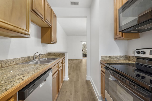 15284 331 Business Unit 11B, Freeport, FL 32439 - kitchen with appliances with stainless steel finishes, light wood-style floors, baseboards, a sink, and light countertops