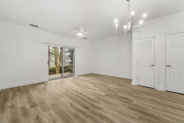 15284 331 Business Unit 11B, Freeport, FL 32439 - empty room with ceiling fan, a chandelier, light wood-type flooring, and baseboards