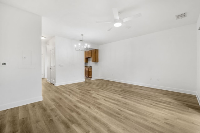 15284 331 Business Unit 11B, Freeport, FL 32439 - unfurnished living room featuring light wood-type flooring, a chandelier, a ceiling fan, and baseboards