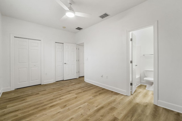 15284 331 Business Unit 11B, Freeport, FL 32439 - unfurnished bedroom with multiple closets, light wood-type flooring, ensuite bath, baseboards, and ceiling fan