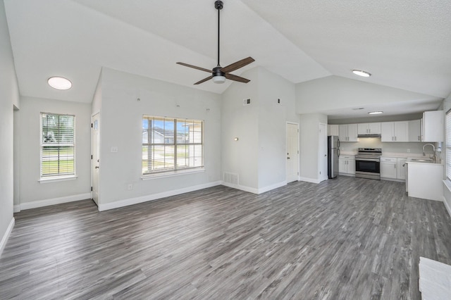 2129 Hillary Ln, Navarre, FL 32566 - unfurnished living room with a sink, wood finished floors, ceiling fan, baseboards, and high vaulted ceiling