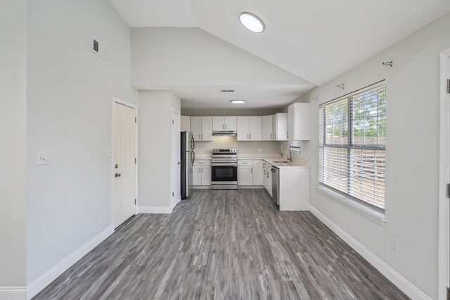 2129 Hillary Ln, Navarre, FL 32566 - kitchen with appliances with stainless steel finishes, a sink, light countertops, wood finished floors, and high vaulted ceiling