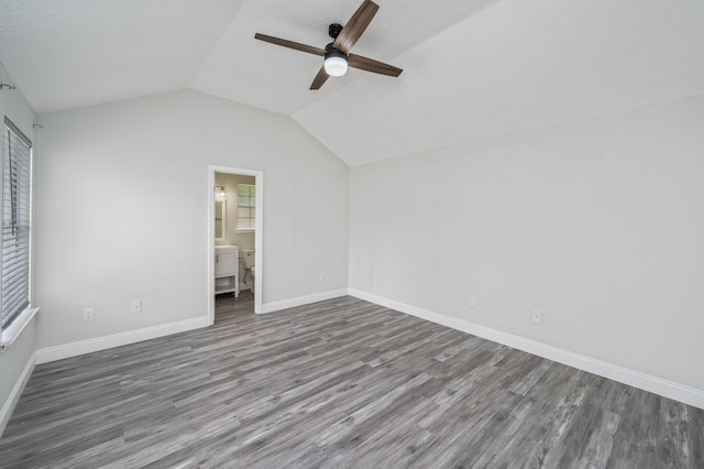 2129 Hillary Ln, Navarre, FL 32566 - unfurnished bedroom with wood finished floors, vaulted ceiling, baseboards, ceiling fan, and ensuite bath