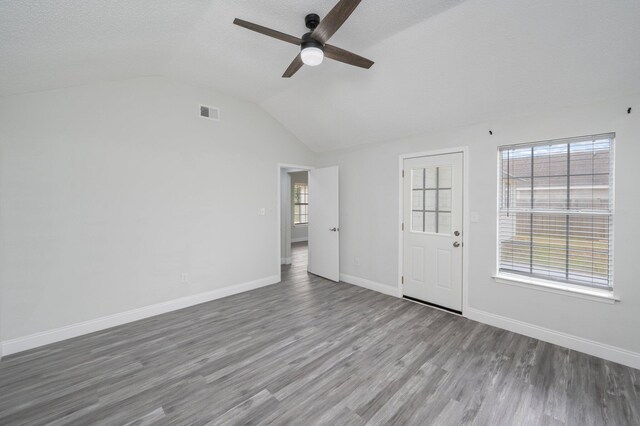 2129 Hillary Ln, Navarre, FL 32566 - unfurnished living room featuring ceiling fan, wood finished floors, vaulted ceiling, baseboards, and a textured ceiling