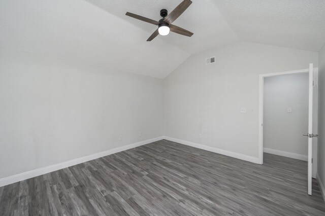 2129 Hillary Ln, Navarre, FL 32566 - additional living space with ceiling fan, vaulted ceiling, dark wood-style floors, baseboards, and a textured ceiling