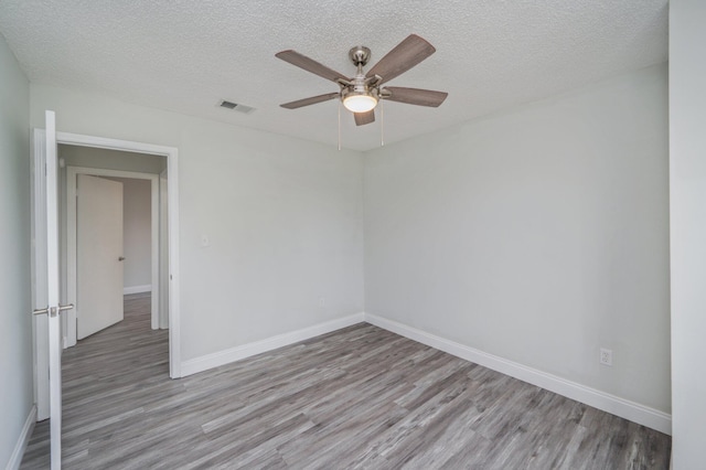 2129 Hillary Ln, Navarre, FL 32566 - empty room with light wood-style flooring, baseboards, ceiling fan, and a textured ceiling