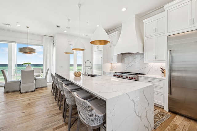 323 Pompano St, Inlet Beach, FL 32461 - kitchen with built in refrigerator, custom range hood, a sink, backsplash, and light wood-type flooring