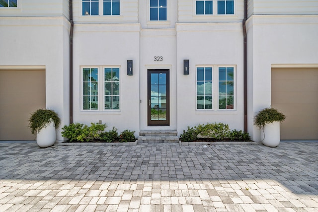 323 Pompano St, Inlet Beach, FL 32461 - doorway to property featuring a garage, stucco siding, and decorative driveway