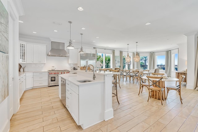 134 Norwood Dr Unit Ph1, Miramar Beach, FL 32550 - kitchen featuring high end appliances, a sink, wall chimney range hood, an island with sink, and backsplash