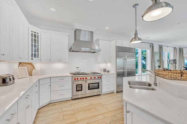 134 Norwood Dr Unit Ph1, Miramar Beach, FL 32550 - kitchen with high end appliances, wall chimney range hood, a sink, white cabinetry, and recessed lighting