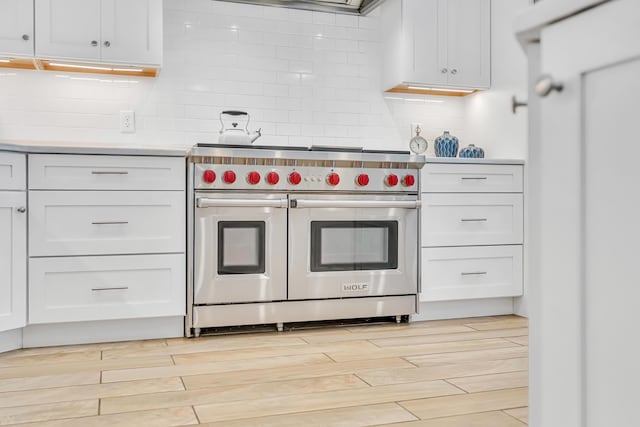 134 Norwood Dr Unit Ph1, Miramar Beach, FL 32550 - kitchen featuring range with two ovens, light countertops, backsplash, and light wood finished floors