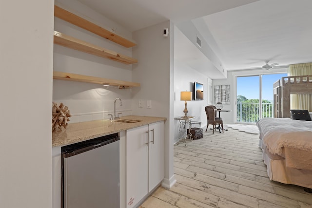 9800 Grand Sandestin Blvd Unit 5602/5604, Sandestin, FL 32550 - kitchen featuring a sink, stainless steel dishwasher, light wood-type flooring, white cabinetry, and open floor plan