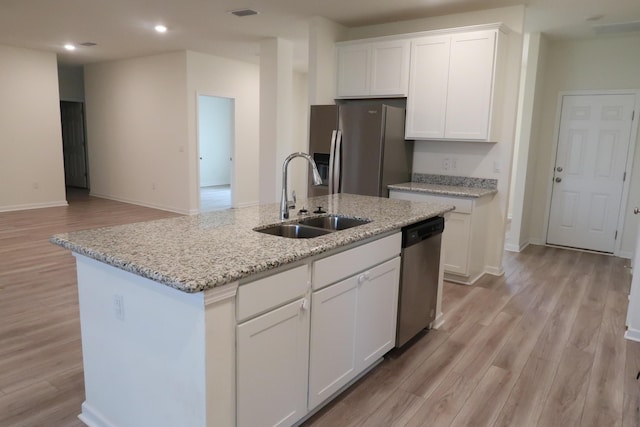 106 E Sky Way, Freeport, FL 32439 - kitchen with appliances with stainless steel finishes, a sink, light wood finished floors, white cabinets, and a kitchen island with sink