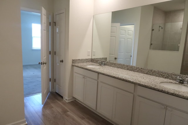 106 E Sky Way, Freeport, FL 32439 - full bath with double vanity, wood finished floors, a tile shower, and baseboards