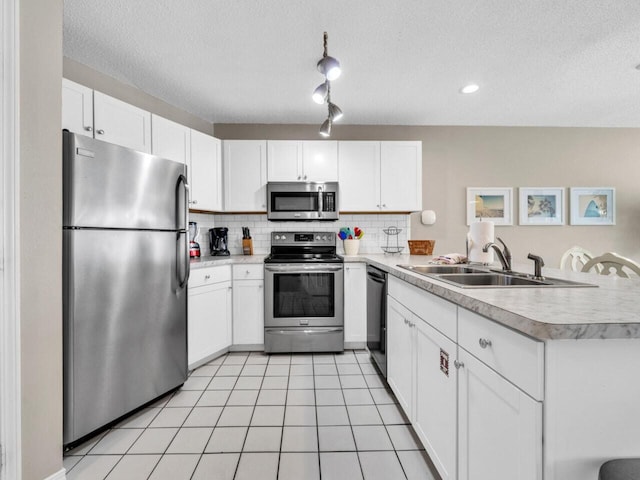 2606 Scenic Gulf Dr Unit 3208, Miramar Beach, FL 32550 - kitchen with stainless steel appliances, a sink, a peninsula, light countertops, and decorative backsplash
