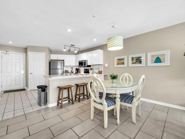 2606 Scenic Gulf Dr Unit 3208, Miramar Beach, FL 32550 - dining room featuring a textured ceiling, baseboards, and recessed lighting
