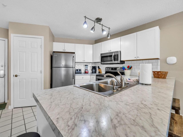 2606 Scenic Gulf Dr Unit 3208, Miramar Beach, FL 32550 - kitchen with stainless steel appliances, a peninsula, white cabinetry, tasteful backsplash, and a textured ceiling