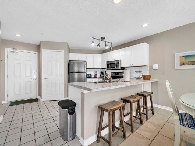 2606 Scenic Gulf Dr Unit 3208, Miramar Beach, FL 32550 - kitchen featuring stainless steel appliances, a peninsula, backsplash, a sink, and light countertops