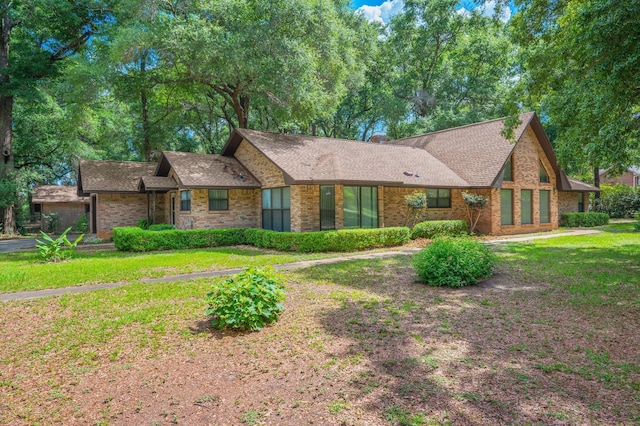 1131 Stanley Ln, Baker, FL 32531 - view of front facade with brick siding, a shingled roof, and a front yard