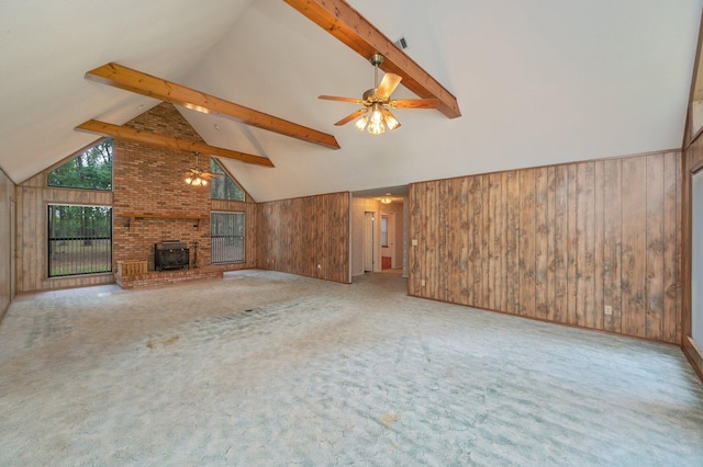 1131 Stanley Ln, Baker, FL 32531 - unfurnished living room with wood walls, ceiling fan, high vaulted ceiling, beamed ceiling, and carpet flooring