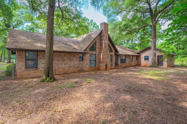 1131 Stanley Ln, Baker, FL 32531 - view of home's exterior with brick siding, a chimney, and a shingled roof