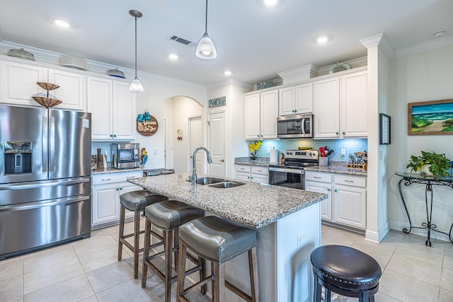 235 Coastal Breeze Dr, Freeport, FL 32439 - kitchen with stainless steel appliances, arched walkways, a sink, light tile patterned flooring, and a kitchen bar