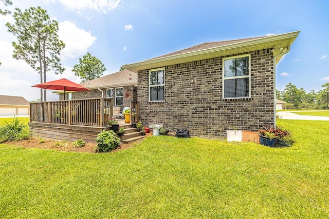 235 Coastal Breeze Dr, Freeport, FL 32439 - rear view of house with brick siding, a wooden deck, and a lawn