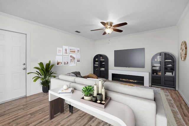 709 Russell Blvd, Fort Walton Beach, FL 32547 - living area with wood finished floors, a ceiling fan, crown molding, baseboards, and a lit fireplace