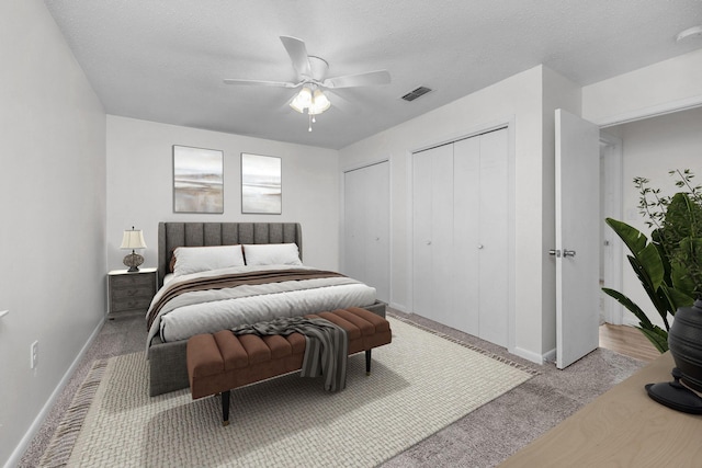 709 Russell Blvd, Fort Walton Beach, FL 32547 - bedroom with multiple closets, light colored carpet, baseboards, ceiling fan, and a textured ceiling