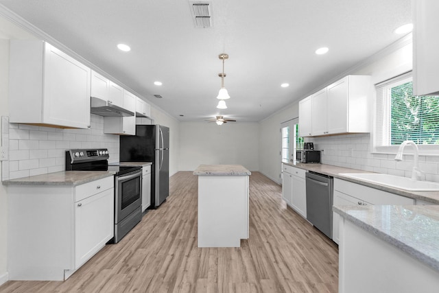 709 Russell Blvd, Fort Walton Beach, FL 32547 - kitchen with appliances with stainless steel finishes, a sink, a center island, under cabinet range hood, and healthy amount of natural light