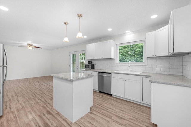 709 Russell Blvd, Fort Walton Beach, FL 32547 - kitchen with stainless steel appliances, a sink, light wood-type flooring, backsplash, and white cabinetry