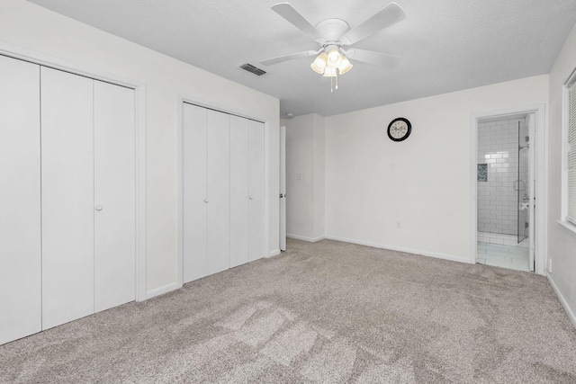 709 Russell Blvd, Fort Walton Beach, FL 32547 - unfurnished bedroom featuring multiple closets, carpet flooring, ensuite bath, a ceiling fan, and baseboards