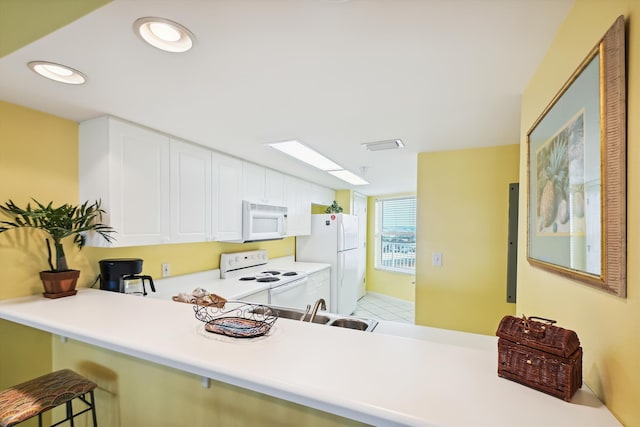 895 Santa Rosa Blvd Unit 707, Fort Walton Beach, FL 32548 - kitchen with white appliances, white cabinetry, light countertops, a kitchen breakfast bar, and a peninsula