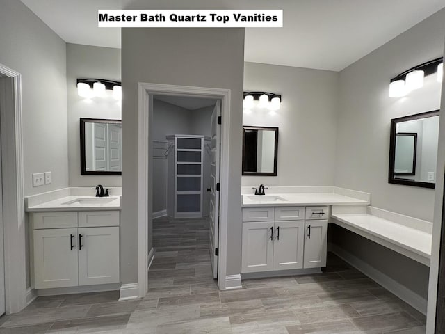 2675 Brodie Ln, Crestview, FL 32536 - full bath with two vanities, a walk in closet, wood finished floors, and baseboards