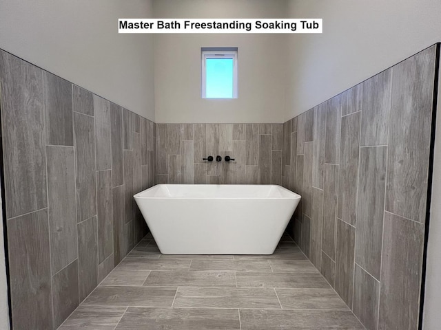 2675 Brodie Ln, Crestview, FL 32536 - bathroom featuring a soaking tub and tile walls