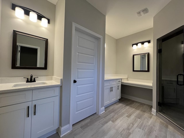2675 Brodie Ln, Crestview, FL 32536 - full bathroom featuring two vanities, a stall shower, wood finished floors, and baseboards