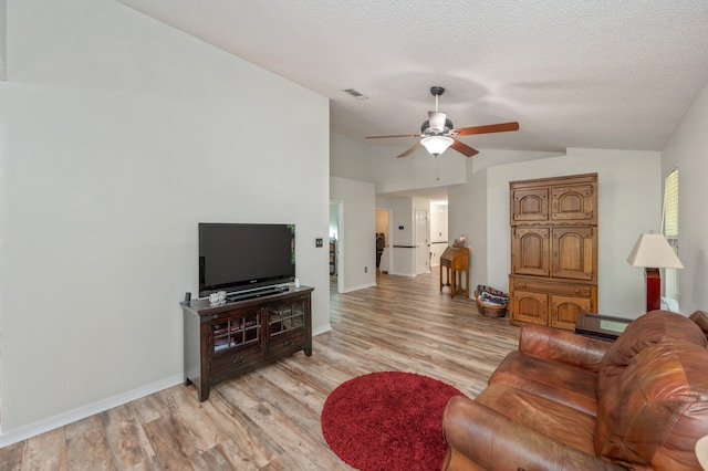 5420 Flag Tail Ln, Crestview, FL 32539 - living area featuring vaulted ceiling, light wood-style floors, a ceiling fan, baseboards, and a textured ceiling