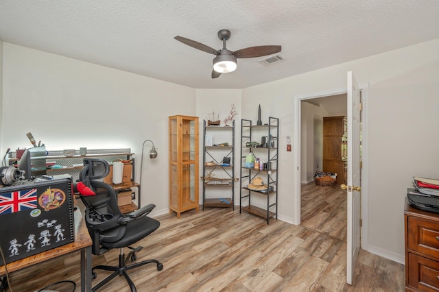 5420 Flag Tail Ln, Crestview, FL 32539 - home office featuring light wood-type flooring, a ceiling fan, baseboards, and a textured ceiling